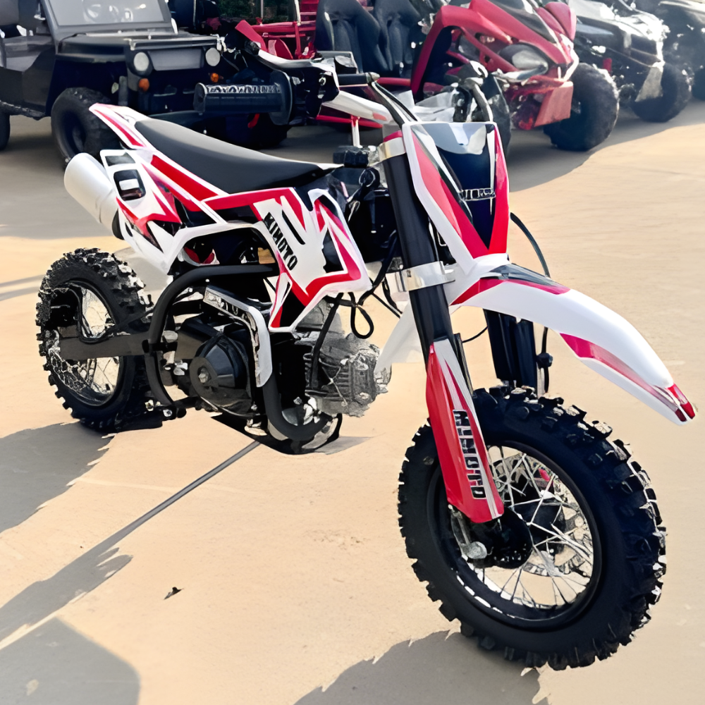 Red and white dirt bike on a concrete surface with other bikes in the background