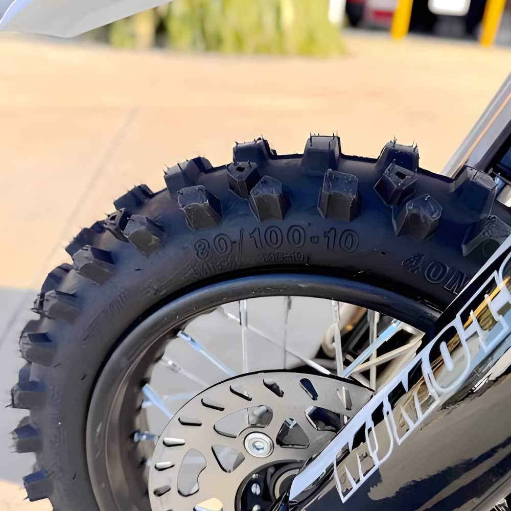 Close-up of a motorcycle tire with tread pattern and rim details.