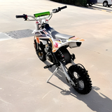 Small dirt bike on a concrete surface with a blurred background