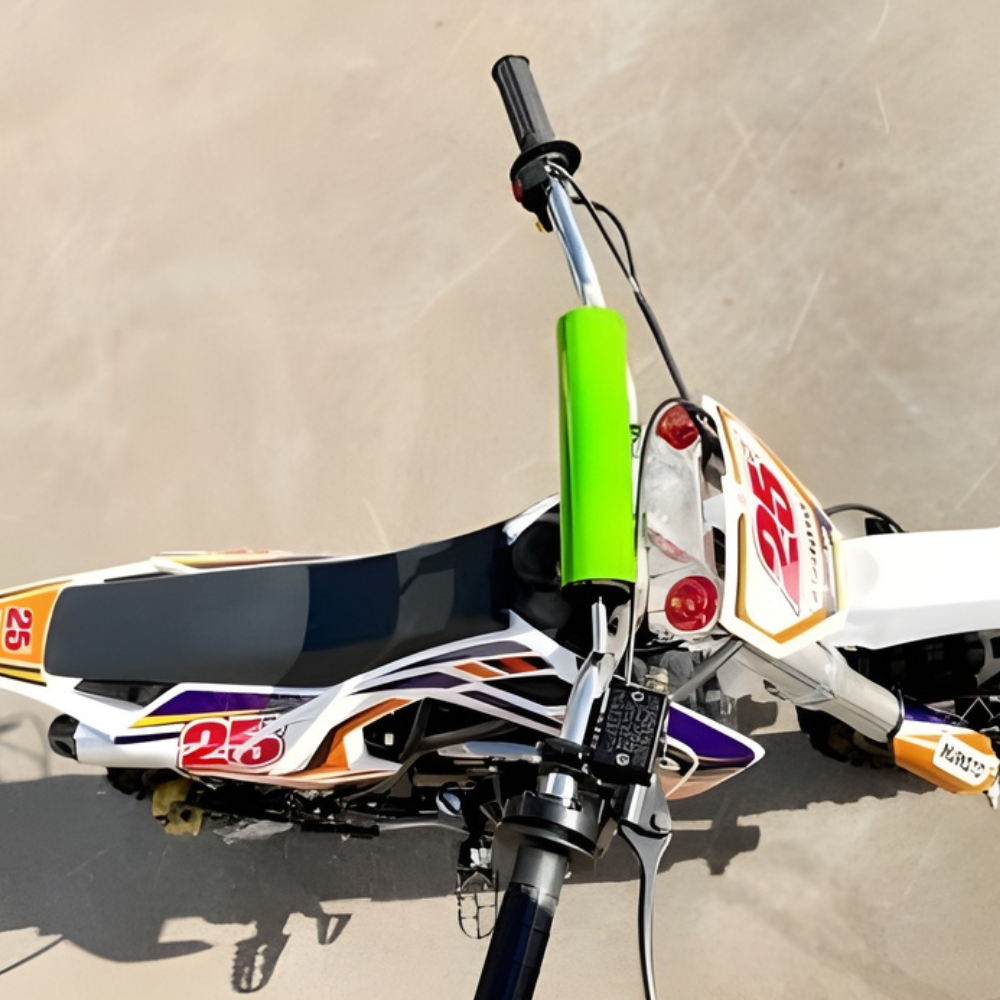 Close-up of a dirt bike with a green suspension fork on a concrete surface