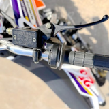 Close-up of motorcycle handlebar controls with a blurred background