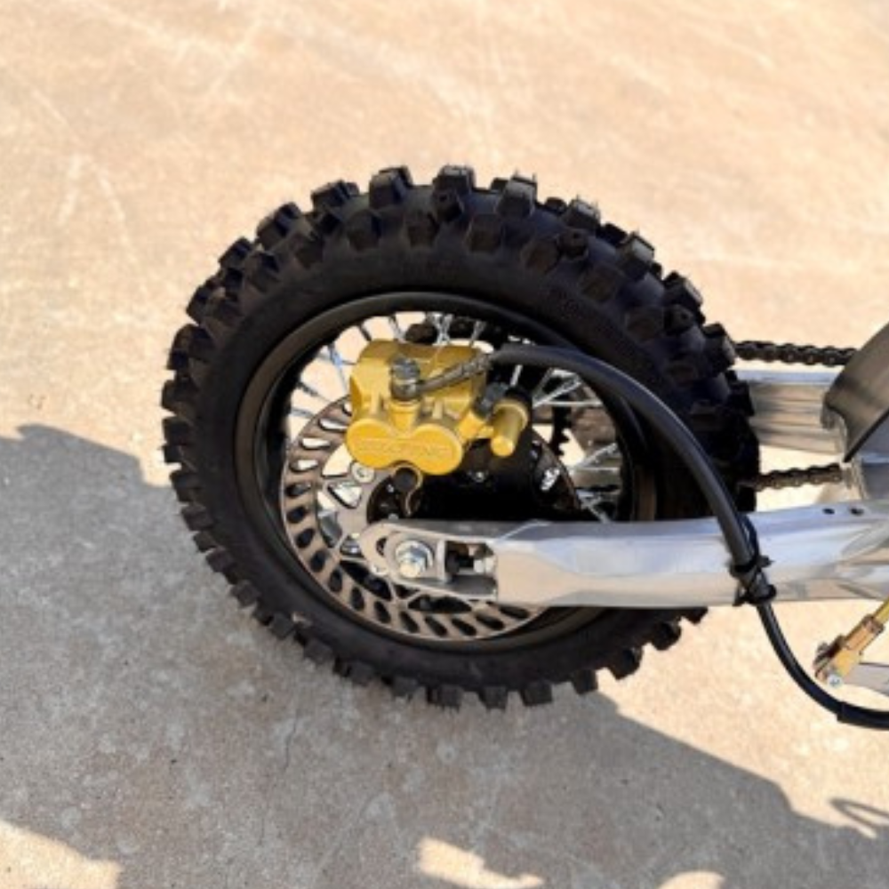 Close-up of a motorcycle wheel with knobby tire on a concrete surface