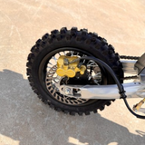 Close-up of a motorcycle wheel with knobby tire on a concrete surface