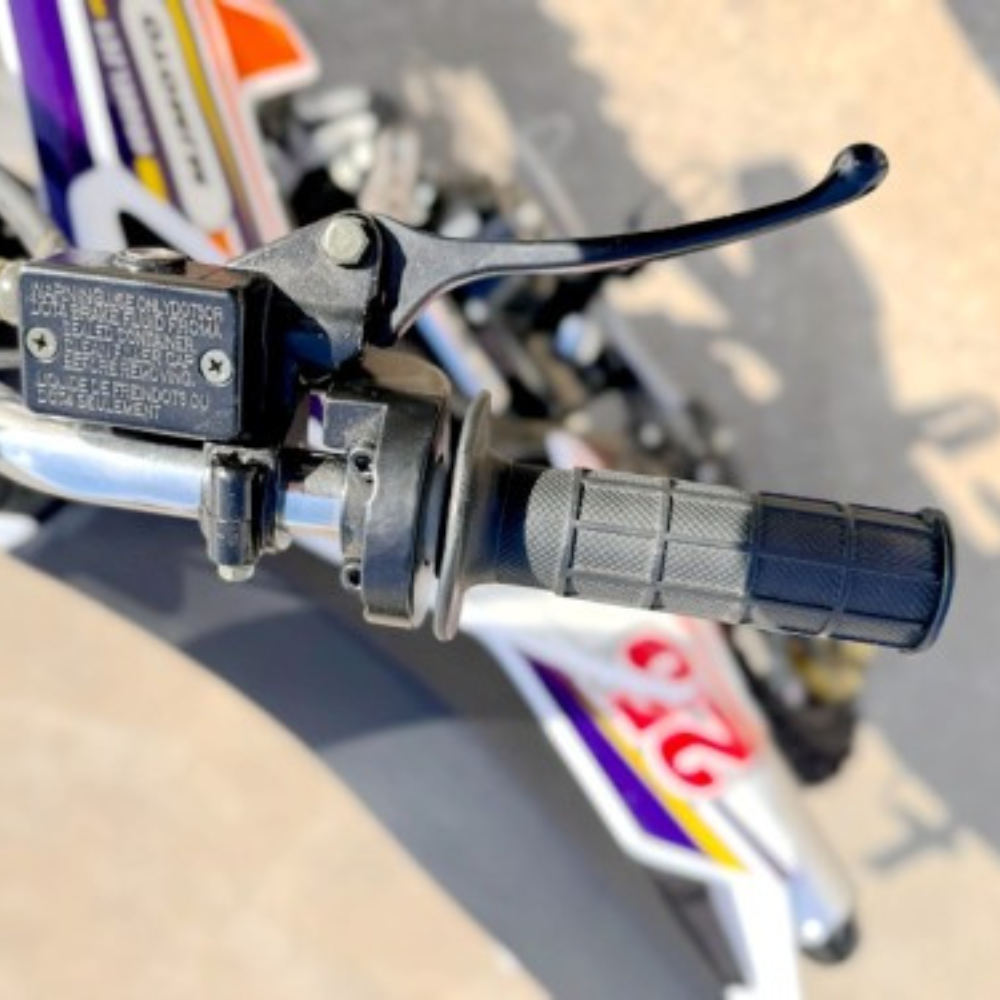Close-up of a motorcycle handlebar with throttle and brake lever.