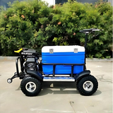 Small utility vehicle with a blue cooler on a paved surface with greenery in the background
