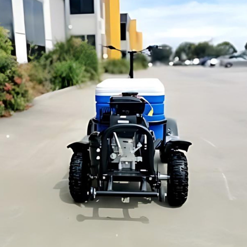 Small tractor on a paved road with buildings and trees in the background