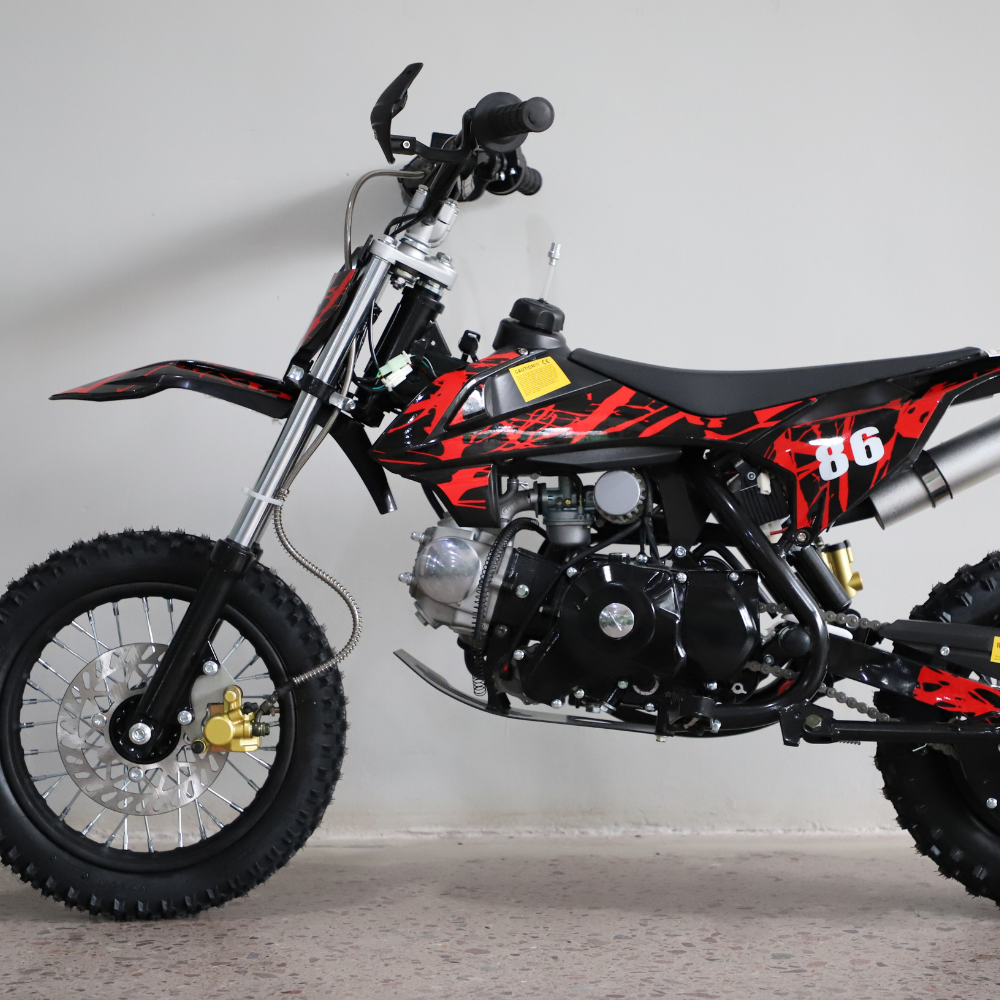 Left-side studio image of the dirt bike, highlighting fuel tank, seat contour, and red graphic styling.