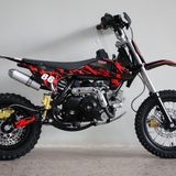 Right-side close-up view of the dirt bike, focusing on engine detail, swingarm, and chain area.