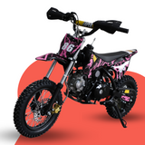 Front-angled studio shot of a pink and black 50cc kids’ dirt bike with number 86 graphics, displayed on a pink and grey backdrop.