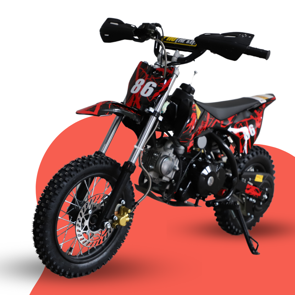 Front-angled studio shot of a red and black 50cc kids’ dirt bike with number 86 graphics, displayed on a red and grey backdrop.