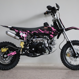 Left-side studio image of the dirt bike, highlighting fuel tank, seat contour, and pink graphic styling.

