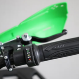 Close-up of a motorcycle handlebar with control buttons on a green background