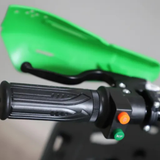 Close-up of motorcycle handlebar with green fairing on a blurred background