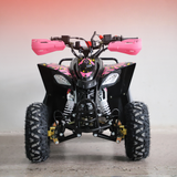 A black quad bike ATV with bright pink hand grips and pink graphic decals, photographed from the front against a neutral studio backdrop.