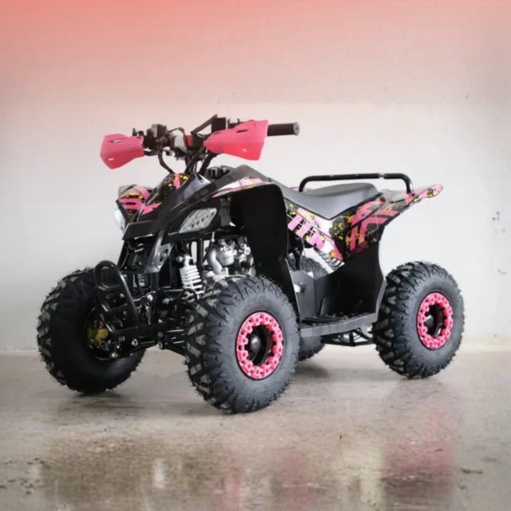 A black quad bike ATV with bright pink accents, including the handlebar grips, wheel rims, and decorative decals, parked on a concrete floor against a plain wall.
