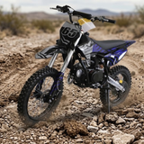 A youth dirt bike with a black, white, and blue color scheme, featuring the number 65 on the front fender, shown riding on a rocky dirt track in a desert landscape.
