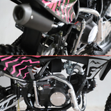 Close-up of a small off-road dirt bike or mini motorcycle showing the engine, exhaust, frame, and patterned body panels in black and bright pink.