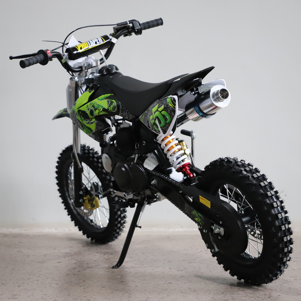 Children's dirt bike with green and black design on a gray background