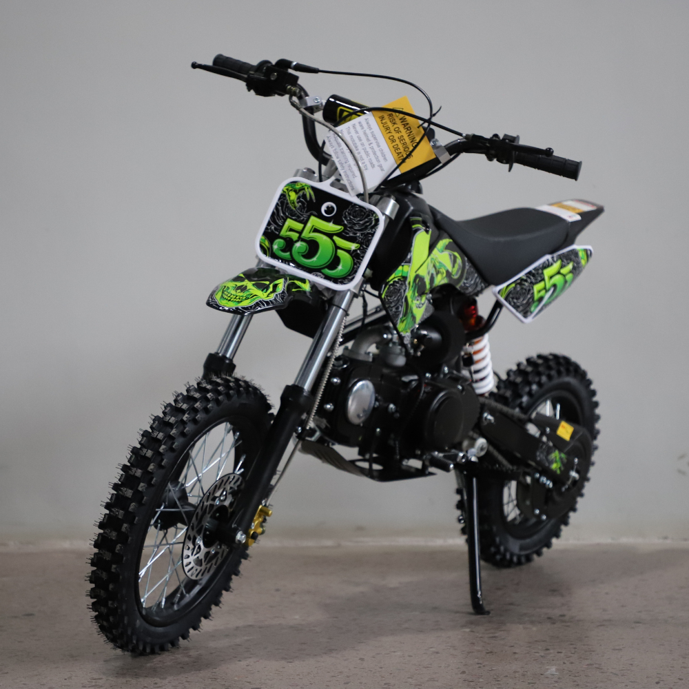 Children's dirt bike with green and black design on a gray background