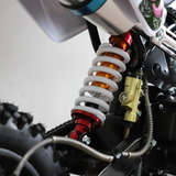 Close-up of a motorcycle suspension system with visible branding on a white background