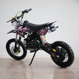 Black and pink dirt bike on a concrete floor with a white background