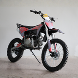A mini dirt bike with a black and red body, silver engine, and knobby tires, shown on a kickstand in a studio setting.