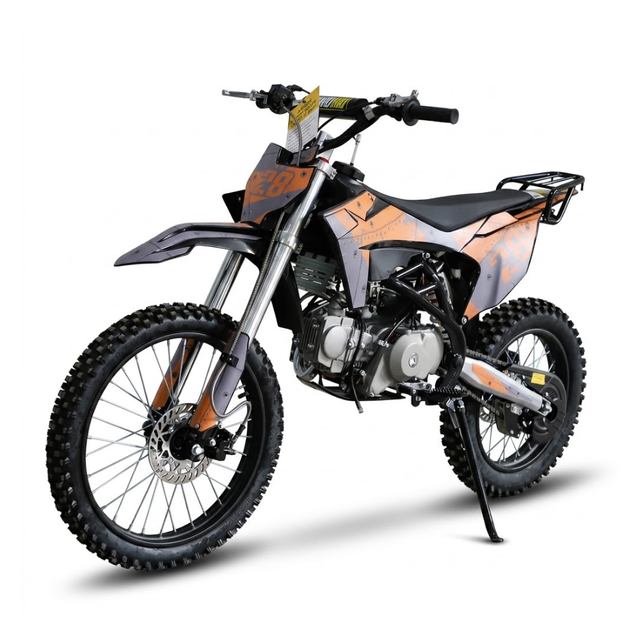 A mini dirt bike with a black and orange color scheme, featuring knobby off-road tires, a silver engine, and a rear luggage rack, shown on a white background with a shadow.