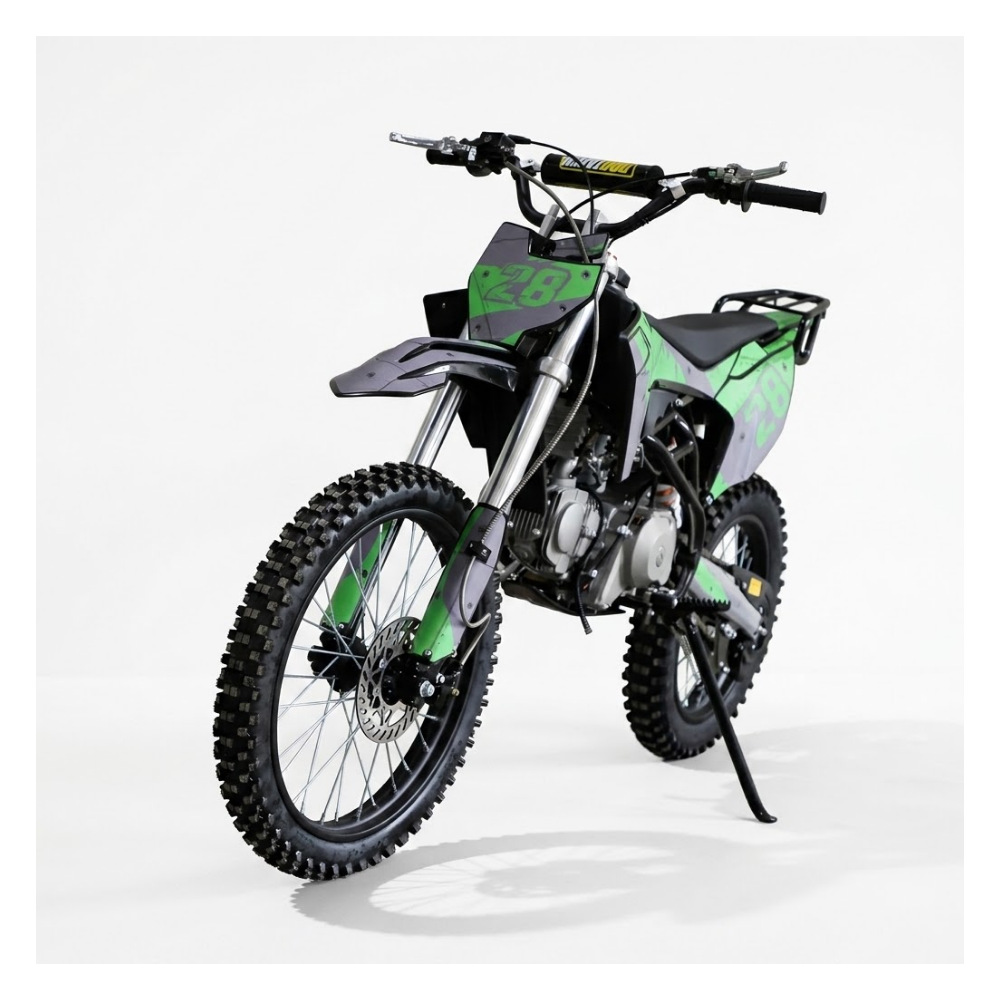 A dirt bike with a black and green color scheme, featuring knobby off-road tires, a black seat, and a rear luggage rack, photographed on a light gray studio background.