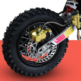 A close-up of the dirt bike’s rear wheel and suspension, highlighting the braking system and tyre tread.