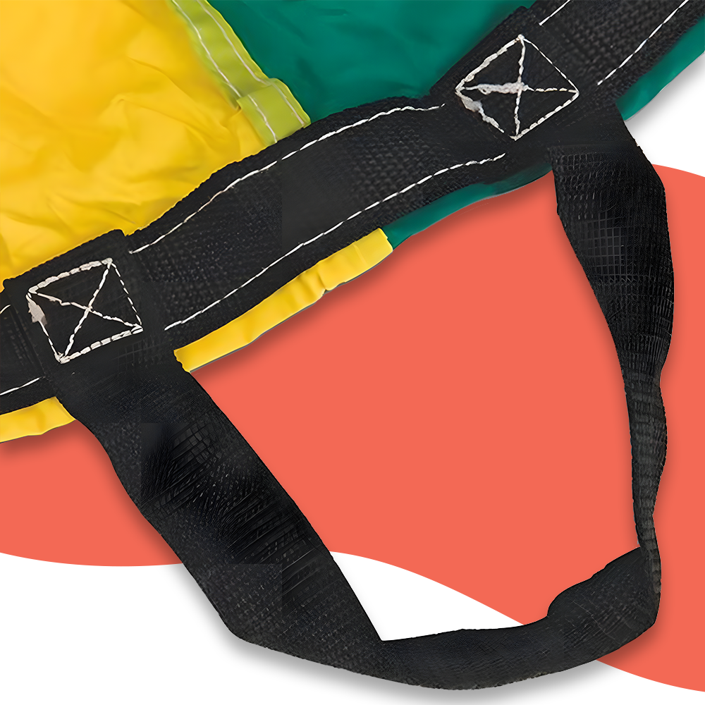 Close-up of a multi-coloured parachute's edge, featuring yellow and green sections with a reinforced black handle and stitching against a red background