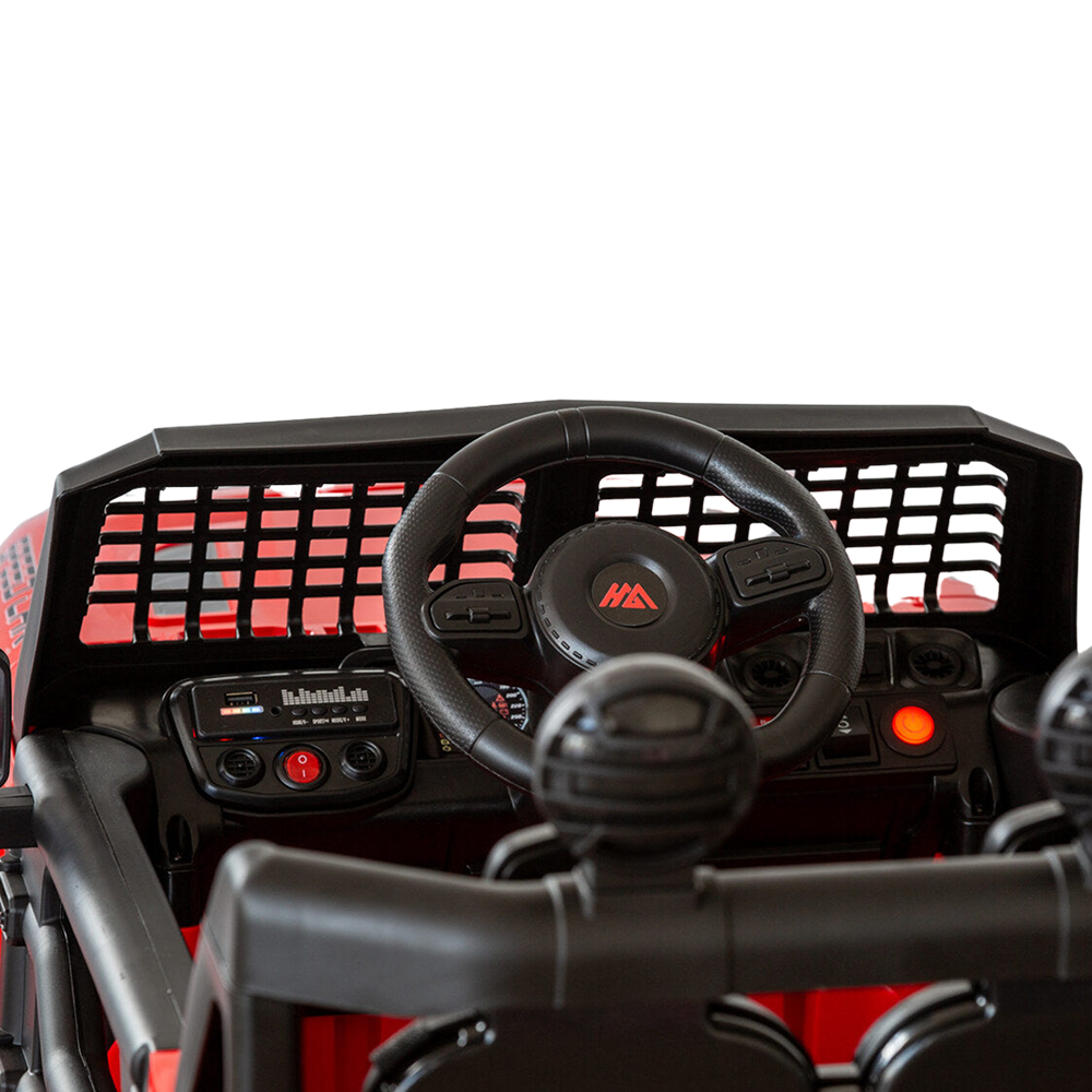 Close-up of the steering wheel and dashboard inside a red Jeep-inspired remote-controlled ride-on electric car, showing controls and details.