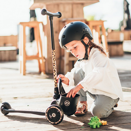 kid beside the Scoot & Ride Highwaykick 2 Kids 3-Wheel Scooter with Storage - Leopard