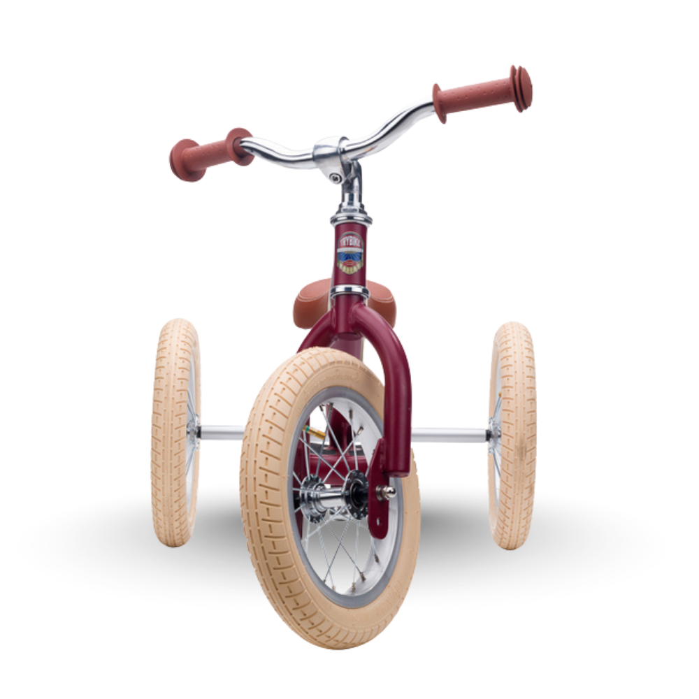 Children's tricycle with beige tires and red frame on a white background