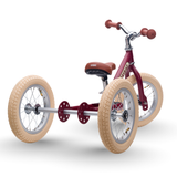 Red tricycle with beige tires on a white background
