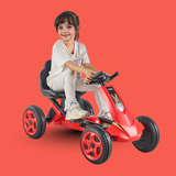 Child sitting on a red toy car against a red background