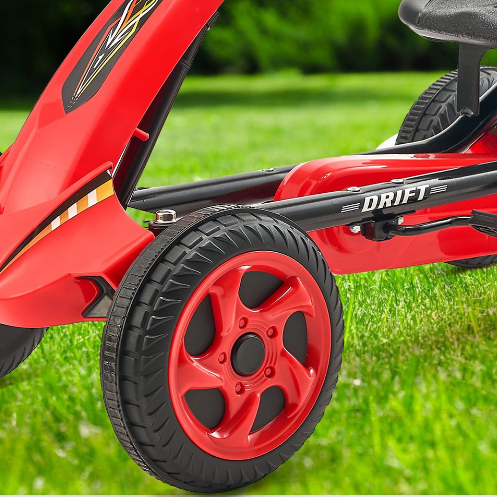 Red children's tricycle with 'DRIFT' branding on a grassy background