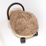 a fluffy brown seat of a wheely bug hedgehog on a white background
