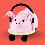 Pink pig-shaped toy with wheels on a red background