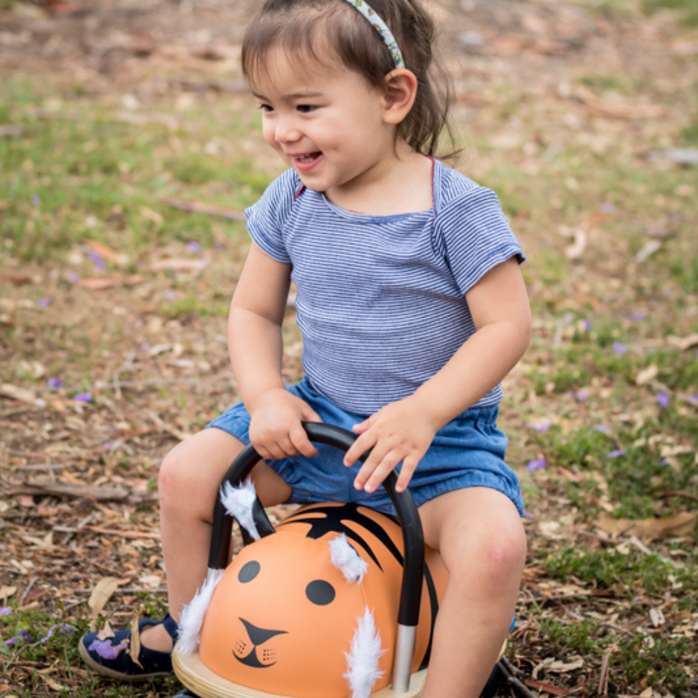 Child sitting on a pumpkin-shaped toy outdoors