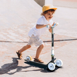 Child riding a scooter on a concrete surface