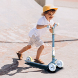 Child riding a scooter on a concrete surface