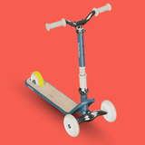 Children's scooter with a wooden deck on a red background