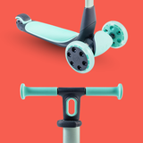 Children's scooter with turquoise deck and handlebar on a red background