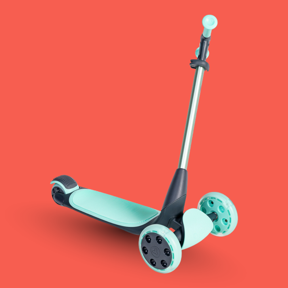 Children's scooter with teal deck and wheels on a red background