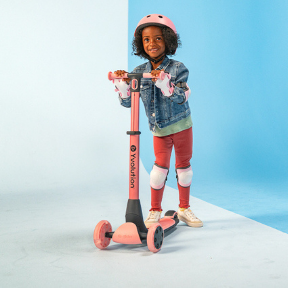 Child with a pink scooter on a light blue background