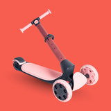 Children's scooter with pink and black design on a red background
