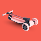 Pink and black scooter with white wheels on a red background