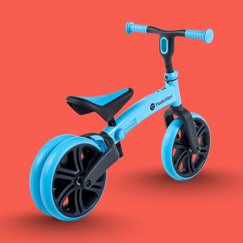 Blue balance bike with black wheels on a red background