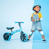 Child with a blue balance bike on a light blue background