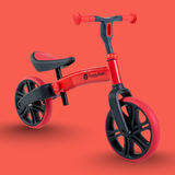 Red and black balance bike on a red background